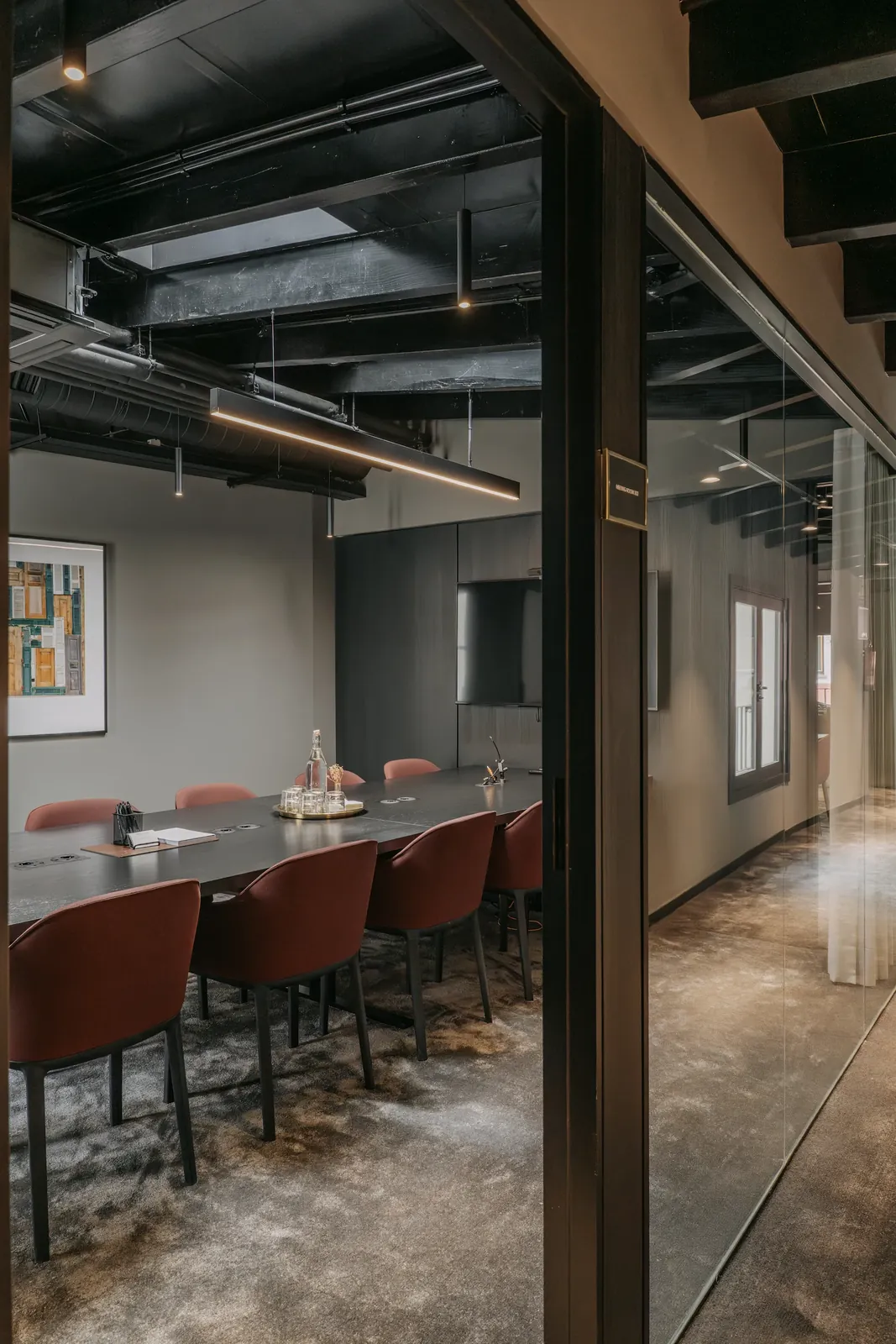 Acceso acristalado a una sala de reuniones de CONVENDUM Palma, con mesa y sillas visibles en el interior.