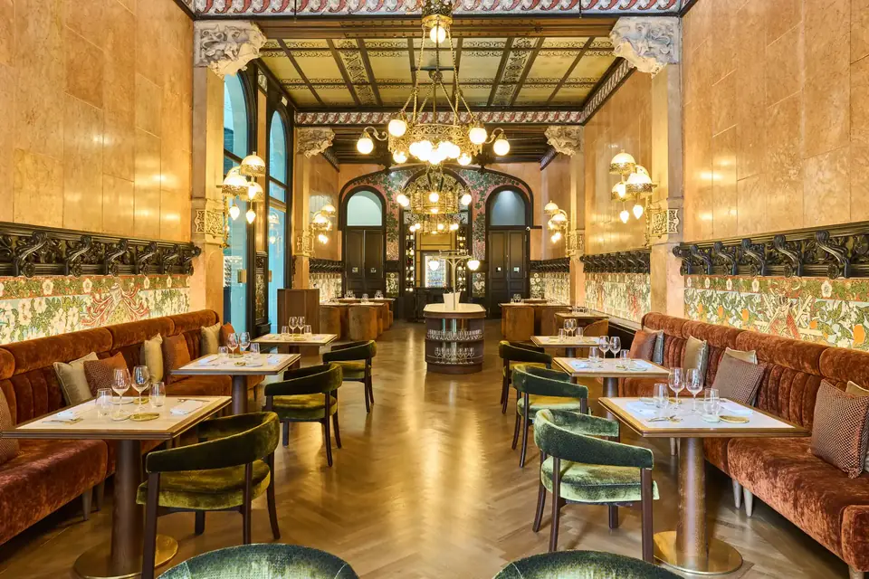 Restaurante del Hotel España Ocean Drive con mesas en dos filas, bancos laterales y techo decorado.