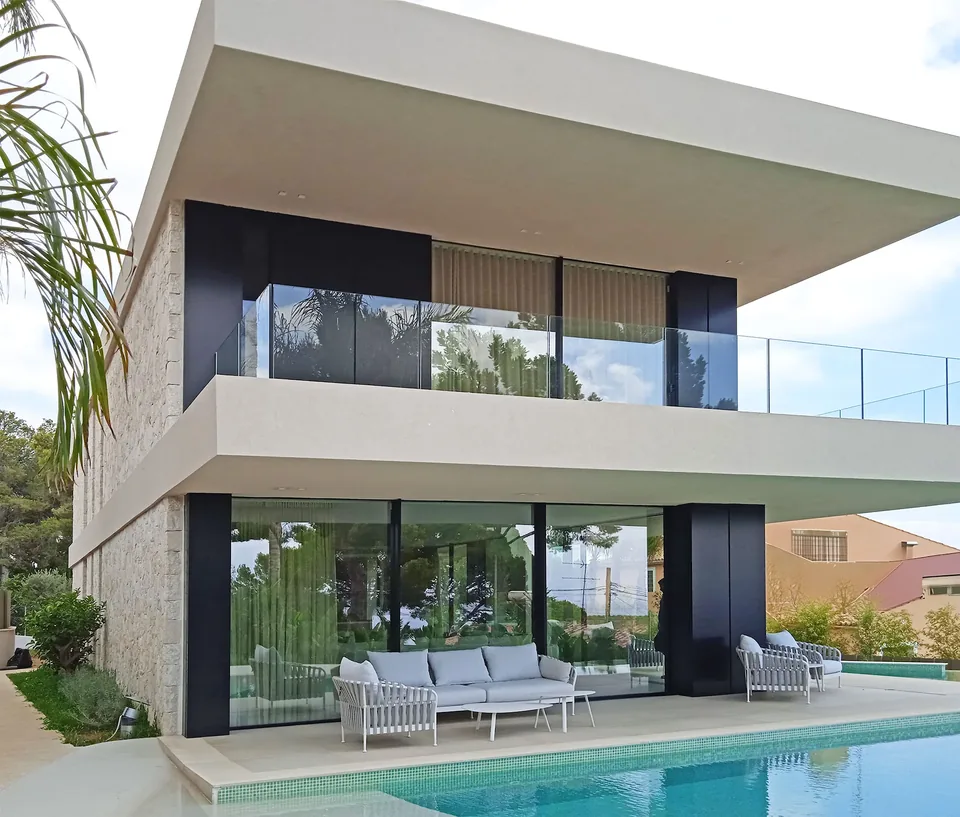Fachada de Nesho en Costa d’en Blanes con dos plantas, terraza acristalada y piscina en primer plano.