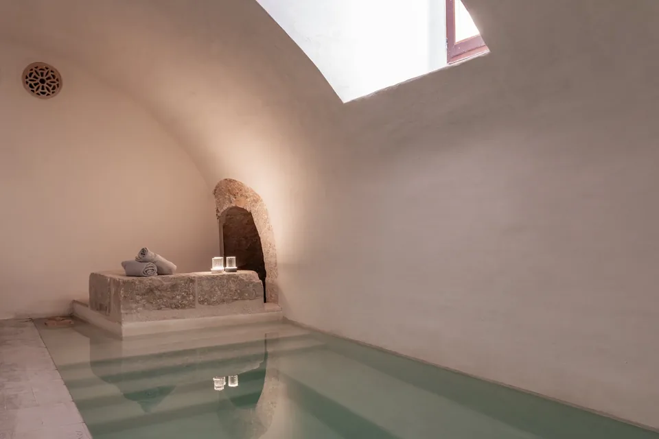 Piscina interior de Nobis Hotel Palma con escalones, paredes claras y luz desde un lucernario.