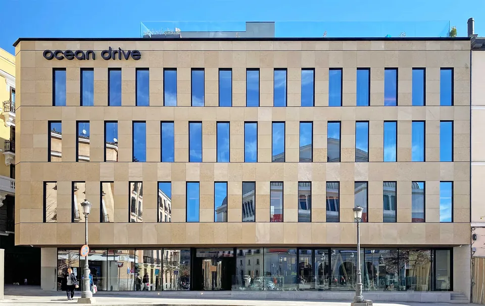 Fachada de Ocean Drive Madrid con ventanas verticales, rótulo en la parte superior y planta baja acristalada.