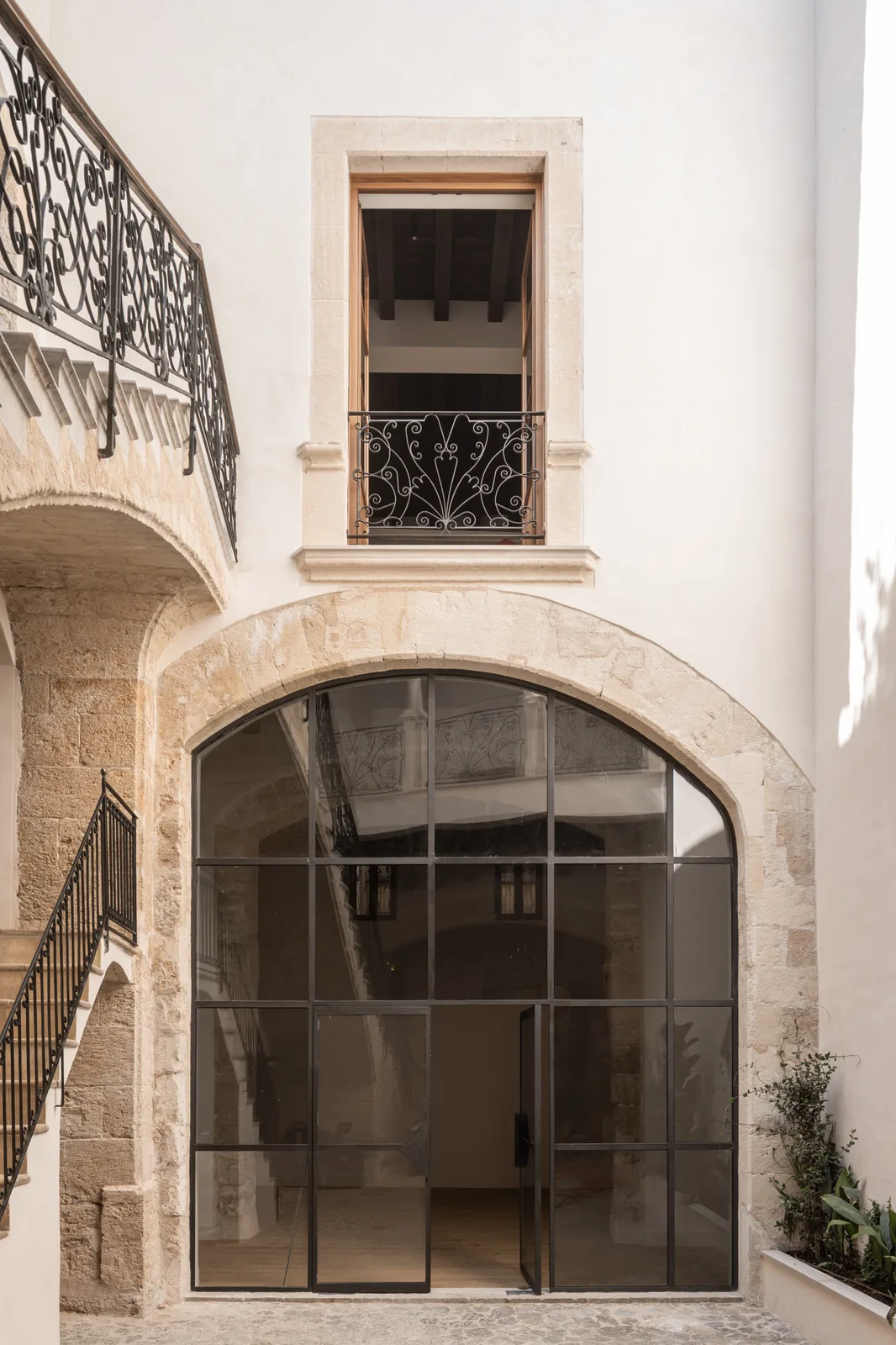 Acceso de la Carrer Sol en Palma bajo un arco, con cerramiento de vidrio y barandillas ornamentadas en la planta superior.