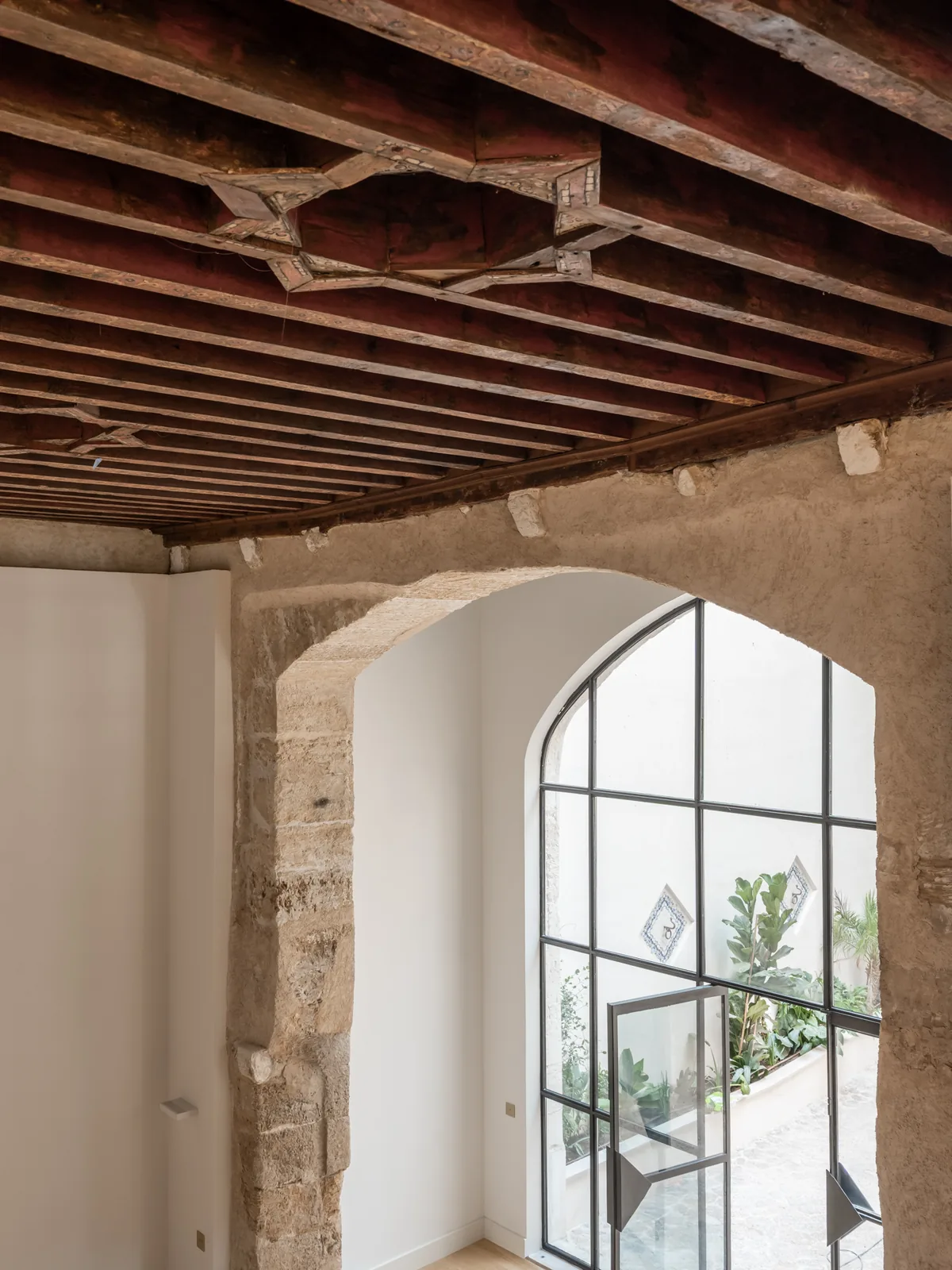 Interior rehabilitado de Carrer Sol con arco y vigas de madera conservadas