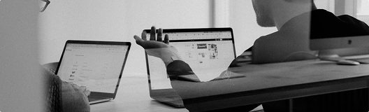 Ahorro de costes en construcción: optimización de recursos y mejor relación calidad-precio Profesionales en una oficina analizando informes en laptops