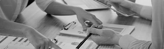 Transparencia en el proceso de construcción: comunicación clara y reportes constantes Manos revisando documentos y gráficos en una reunión de trabajo